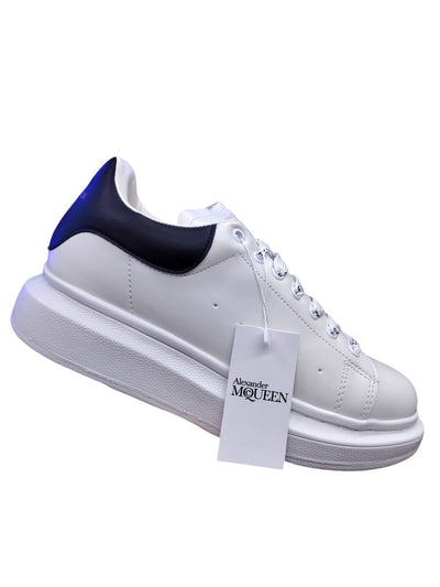 White and black Alexander McQueen-style casual sneakers with a sleek design and bold silhouette.