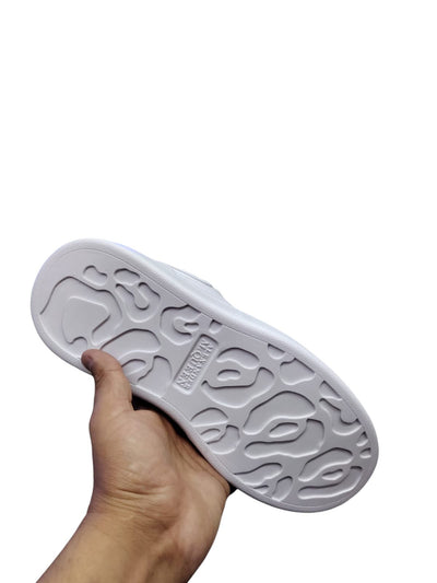 White and black Alexander McQueen-style casual sneakers with a sleek design and bold silhouette.