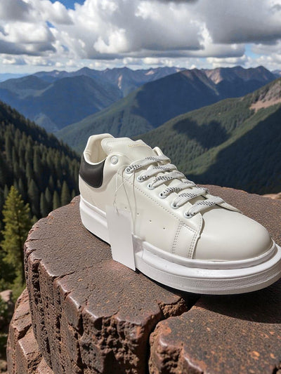 White and black Alexander McQueen-style casual sneakers with a sleek design and modern aesthetic.